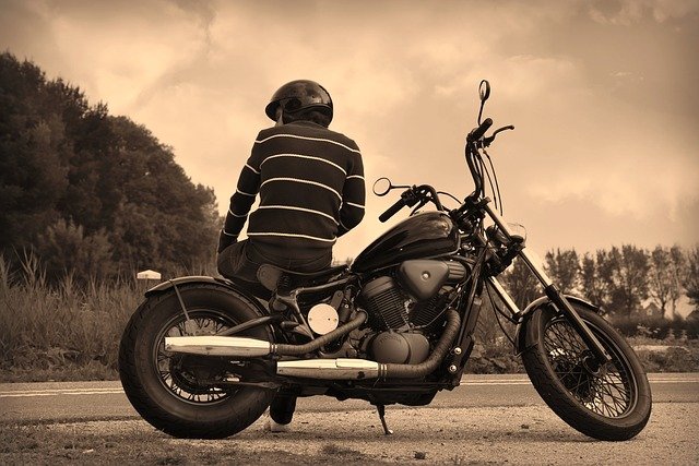 muž sediaci na motorke